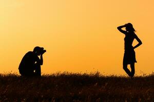 silhueta do uma homem fotografando mulher foto