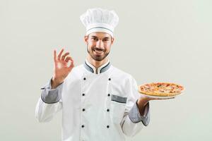 chefe de cozinha segurando pizza e mostrando Está bem placa foto