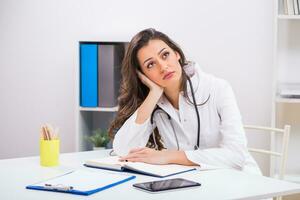 triste fêmea médico sentado às dela escritório foto