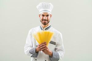 chefe de cozinha é segurando espaguete em cinzento fundo foto