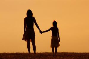 mãe e filha apreciar assistindo pôr do sol juntos foto