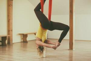 mulher fazendo aéreo ioga dentro a ginástica estúdio foto