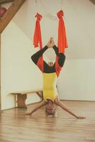 mulher fazendo aéreo ioga dentro a ginástica estúdio foto