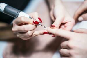 fechar acima imagem do manicure processo, remoção do velho gel verniz a partir de unha da mão com elétrico unha furar. foco em unha da mão. foto