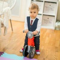 imagem do fofa pequeno bebê Garoto equitação dele primeiro bicicleta foto