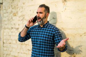 homem de negocios com uma barba tendo conflito enquanto falando com alguém em a telefone foto