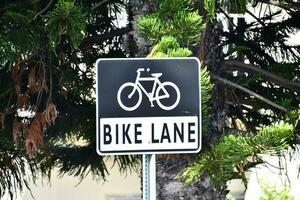 uma bicicleta faixa placa é mostrando dentro frente do uma árvore foto