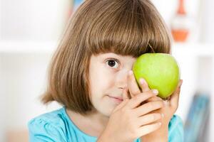 pequeno menina segurando maçã foto