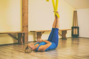 mulher fazendo aéreo ioga dentro a ginástica estúdio foto