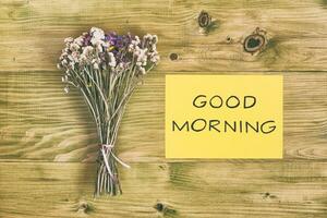 lindo ramalhete do flores e texto Boa manhã em de madeira mesa foto