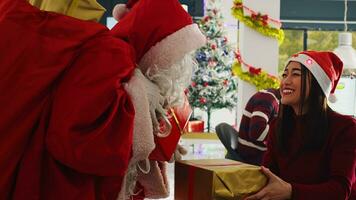 fechar acima tiro do Gerente vestido Como santa claus espalhando feriado alegria dentro festivo adornar escritório, oferta apresenta para funcionários. Supervisor surpreendente animado companhia trabalhadores com Natal presentes foto