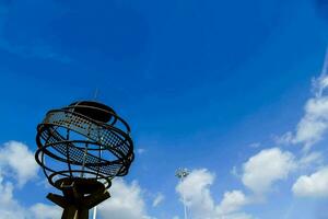 uma metal globo com uma azul céu dentro a fundo foto