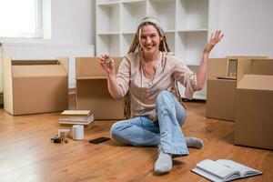 moderno gengibre mulher com tranças mostrando chave do dela Novo casa foto