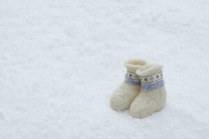 fofa pequeno branco chuteiras ficar de pé em puro neve. seletivo foco.alto qualidade foto