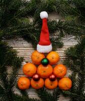 tangerinas guardada em uma mesa dentro a forma do uma Natal árvore com decorações em uma de madeira tabela.seletiva foco . Alto qualidade foto