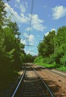 cenário verde de verão com trilhos de trem e céu azul foto