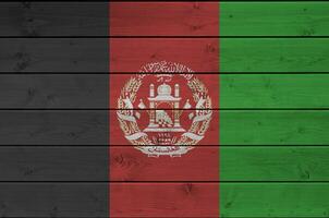 Afeganistão bandeira retratado dentro brilhante pintura cores em velho de madeira muro. texturizado bandeira em rude fundo foto