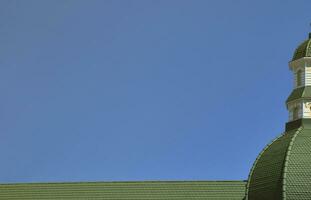 completou o trabalho perfeito de cobertura de alta qualidade a partir de coberturas metálicas. a cúpula de forma poliédrica com uma torre é coberta com telhas metálicas verdes foto