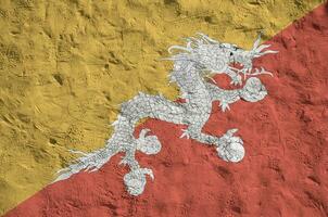 Butão bandeira retratado dentro brilhante pintura cores em velho alívio reboco muro. texturizado bandeira em rude fundo foto