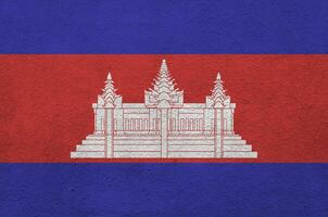 bandeira do camboja retratada em cores de tinta brilhantes na parede de reboco em relevo antigo. banner texturizado em fundo áspero foto