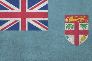 bandeira de fiji retratada em cores de tinta brilhantes na parede de reboco em relevo antigo. banner texturizado em fundo áspero foto