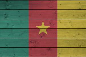 Camarões bandeira retratado dentro brilhante pintura cores em velho de madeira muro. texturizado bandeira em rude fundo foto