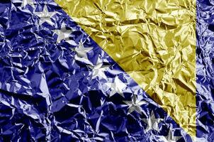 Bósnia e herzegovina bandeira retratado dentro pintura cores em brilhante amassado alumínio frustrar fechar-se. texturizado bandeira em rude fundo foto