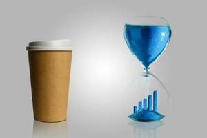 café pausa dentro a processo, café dentro uma papel copo e ampulheta azul fundo. abstrato. foto