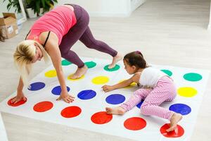 criança menina e mãe jogando juntos às casa foto