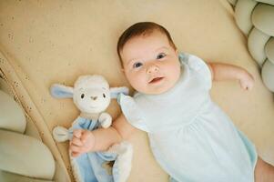 adorável feliz 6 meses velho bebê deitado dentro berço, jogar tempo, topo Visão foto