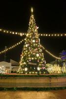 lindo Natal árvore dentro uma Cidade quadrado às noite foto