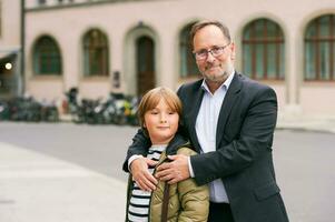 ao ar livre retrato do pai e filho, meio era homem com jovem criança posando em a rua foto