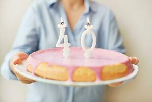 feliz meio era 40. ano velho mulher segurando bolo com velas foto