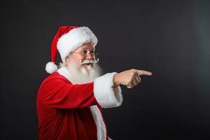 ai gerado santa claus apontando às alguma coisa em uma Preto fundo foto