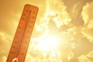 termômetro contra fundo quente, verão amarelo sol quente clima e Alto ar temperatura. foto