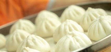 chinês comida, baozi é uma tradicional delicadeza dentro China, pão Comida fotografia tão tentador, delicioso baozi, chinês cozido no vapor carne pão é pronto para comer em servindo prato e vaporizador foto