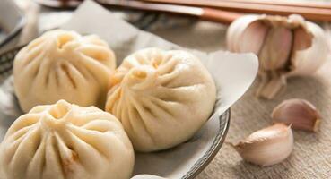 chinês comida, baozi é uma tradicional delicadeza dentro China, pão Comida fotografia tão tentador, delicioso baozi, chinês cozido no vapor carne pão é pronto para comer em servindo prato e vaporizador foto