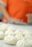 chinês comida, baozi é uma tradicional delicadeza dentro China, pão Comida fotografia tão tentador, delicioso baozi, chinês cozido no vapor carne pão é pronto para comer em servindo prato e vaporizador foto