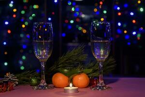 dois óculos do vinho em a mesa. Natal Novo ano luzes e decorações. foto