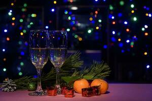 dois óculos do vinho em a mesa. Natal Novo ano luzes e decorações. foto