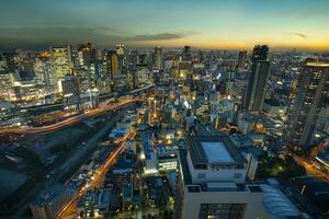 Alto ângulo Visão do Osaka urbano arranha-céu às lindo crepúsculo céu foto