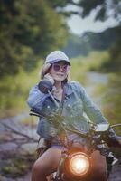 bonita mulher equitação esporte enduro motocicleta em sujeira campo foto