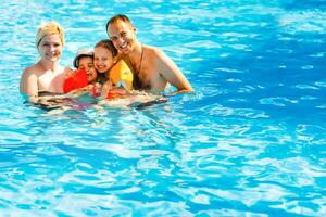 jovem família, pais com crianças, dentro piscina foto