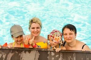 dois mulheres e seus crianças dentro a piscina foto