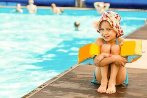 fofa criança pequena menina jogando dentro natação piscina foto