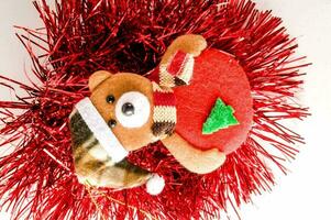 uma Urso de pelúcia Urso vestindo uma vermelho chapéu e segurando uma Natal árvore foto