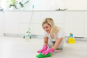 jovem mulher limpeza e esfregar chão às lar. foto