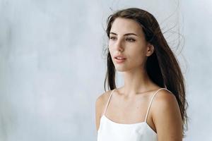 pele perfeita. cintura para cima retrato de jovem sensual, desviando o olhar suavemente. isolado no fundo branco. aparência de mulher e conceito de cuidados com a pele foto