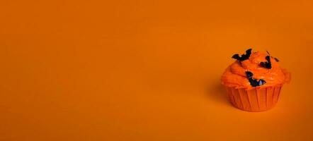 bolos de copo em a laranja fundo. doces para dia das Bruxas celebração. cópia de espaço. foto