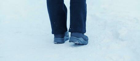 viajante caminhando em a neve, fechar-se à prova d'água chuteiras ou sapatos durante caminhada em Nevado floresta. inverno estação foto